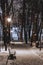 Winter park with benches covered with snow in the evening