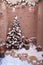 Winter patio decorated with spruce garland, lanterns and Christmas tree.