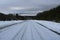 Winter paved road leading to snow covered mountains