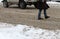 Winter. People walk on a very snowy sidewalk and road. People step on an icy pathway, icy sidewalk. Uncleaned streets and roads