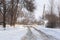 Winter poorly cleared road. Road in the countryside strewn with snow. Winter landscape with snowdrifts