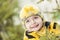 Winter portrait of a 4 year old child in yellow warm clothes with a wide smile. Look up. The branches of the trees around. How to