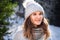 Winter portrait of caucasian blond young smiling happy woman in grey sweater and pompom hat outdoor