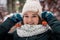 Winter portrait of a charming young woman with freckles on her face. Cute girl looking at the camera on a background of