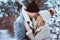 Winter portrait of happy romantic couple embracing and looking to each other outdoor in snowy day