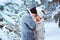 Winter portrait of happy romantic couple warm up each other on the walk in snowy forest