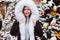 Winter portrait of happy young woman walking in Christmas city streets, decorated with garlands, toys and trees