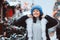 Winter portrait of happy young woman walking in Christmas city streets, decorated with garlands, toys and trees