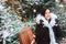 winter portrait of happy young woman walking in Christmas city streets, decorated with garlands, toys and trees, wearing fashion c