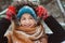 Winter portrait of happy young woman walking in snowy forest in warm outfit