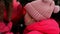 Winter portrait of little 2 years old girl holding red big Christmas ball outdoors