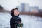 Winter portrait of little kid boy wearing a knitted sweater with deers, outdoors during snowfall.