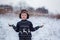 Winter portrait of little kid boy wearing a knitted sweater with deers, outdoors during snowfall.