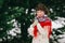 Winter portrait of smiling russian beautiful woman in hand-made red shawl in front of fir-trees