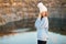 Winter portrait of smilling woman in white hat with big bubo makes funny face