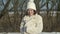 Winter portrait of a teenage girl in a knitted hat on which snow is falling.