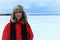 Winter portrait of a woman wearing an furry aviation hat and red jacket