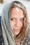 Winter portrait of a young beautiful girl in the snow with drops of melted snowflakes on her face. Dressed in a coat with a polar