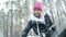 Winter portrait of a young woman clearing snow from a car windshield. Slow motion