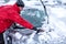 Winter problems of car drivers. Machine, covered with snow. A man brushing snow from the car. man removing snow from car