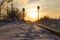 Winter railway to factory in sunset rays.