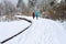 Winter recreation, raised boardwalk trail covered in fresh snowfall and footprints, two people walking