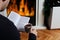 Winter Relaxation at Home: Man Enjoying Tea and a Book by the Fireplace