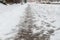 Winter road with melting from salt snow. Close up of sidewalk with slush on snowy day.