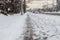 Winter road with melting from salt snow. Close up of sidewalk with slush on snowy day