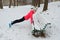 Winter running in park: happy woman runner warming up and exercising before jogging in snow