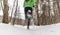 Winter running in snowing forest nature. Woman runner trail running in snow in winter forest landscape. Female cross