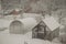 winter, rural greenhouse during snowfall, snow covers the roof of the greenhouse, garden in winter