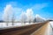 Winter rural landscape with the road the forest and the blue sk