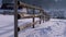 Winter Rural Scene with Old Abandoned Wooden Fence and Snowy Wooden House and Mountains