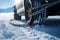 Winter\\\'s challenge met: Snow chain-clad wheel maneuvers through deep snowy landscape.