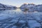 Winter scene of boat in frozen fjord and snowy mountains