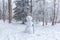 Winter scene in a rest zone near a forest. Benches and snowmen, forest road