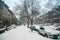 Winter scene with snow covered cars parked along streets in Brooklyn, NY. Brownstones in winter season