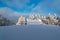 Winter scenery with snow covered isolated chalet, frozen trees, lot of snow and blue sky with clouds