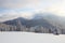 Winter scenery in the sunny day. Mountain landscapes. Trees covered with white snow, lawn and mistery sky.