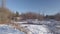Winter scenery on a sunny day near the frozen river going slowly from right to left and up