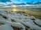 Winter seascape, stones in the snow and sunset.n