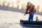 Winter season - fisherman fishing on the frozen lake