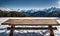 Winter serenity: Empty wooden table with snowy mountain backdrop