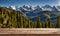 Winter serenity: Empty wooden table with snowy mountain backdrop