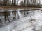 Winter shore of a reservoir covered with cracked ice