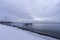 Winter shoreline with broken pier posts standing in tranquil sea