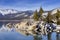 Winter shot of Lake Tahoe with snow on rocks and mountains.