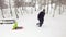 Winter side follow father pulling red bobsled on snowy field with child.Dad, son or daughter, bobsleigh on snow.Family