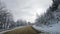 winter snow-covered road in a mountain forest. shooting through the windshield.